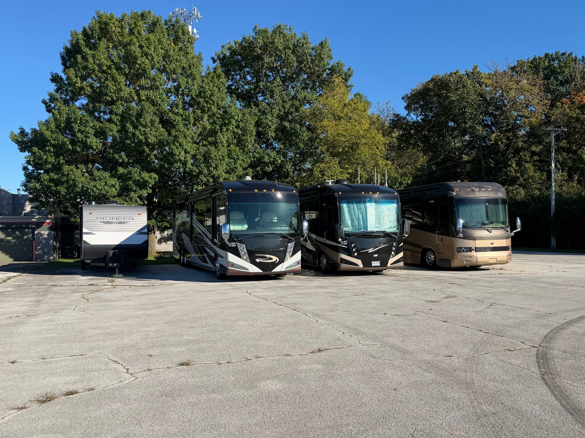 Motorhomes and a travel trailer parked on asphalt in Thunderbird’s Lot A